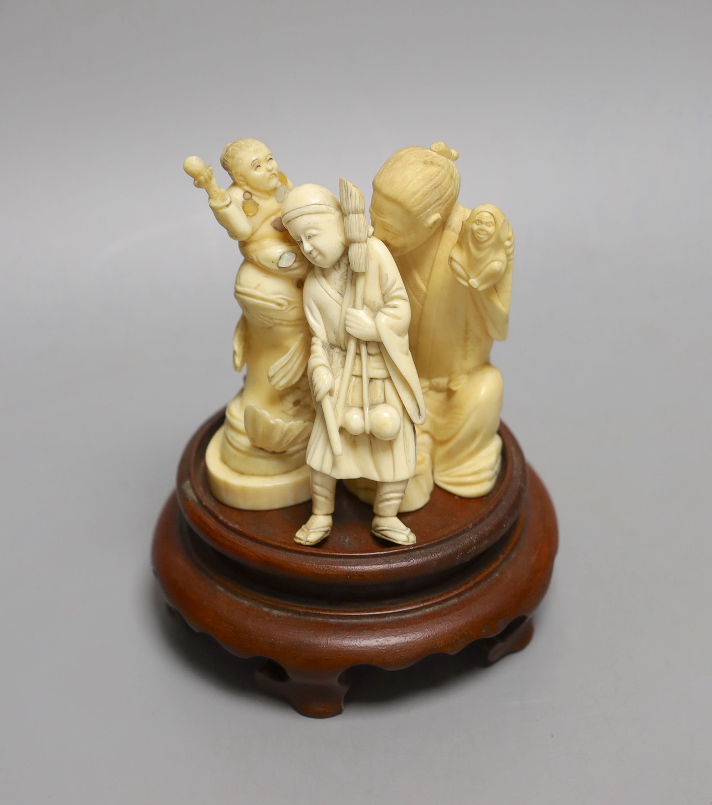 Three Japanese ivory okimono, of a doll maker, a street seller and Kinko seated on a carp, Meiji period - tallest 9.5cm